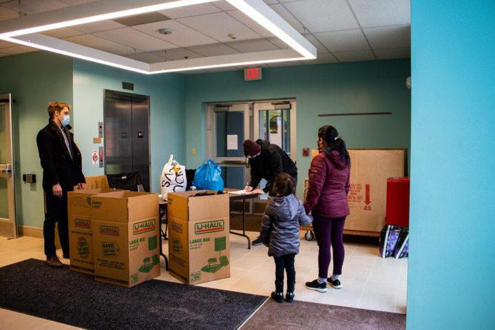 A mother and daughter stand in line at a Americorps coat drive