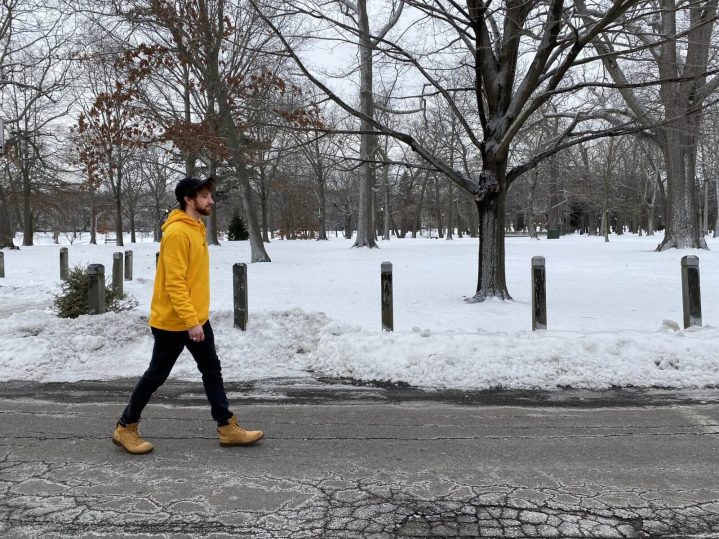 A goodwill workforce peer navigator walks through a park full of snow