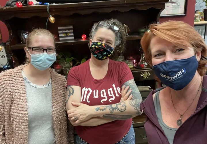 Three women smile through masks