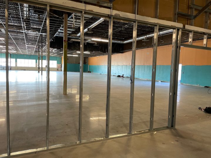 Interior exposed wall beams in a large new and empty business space.