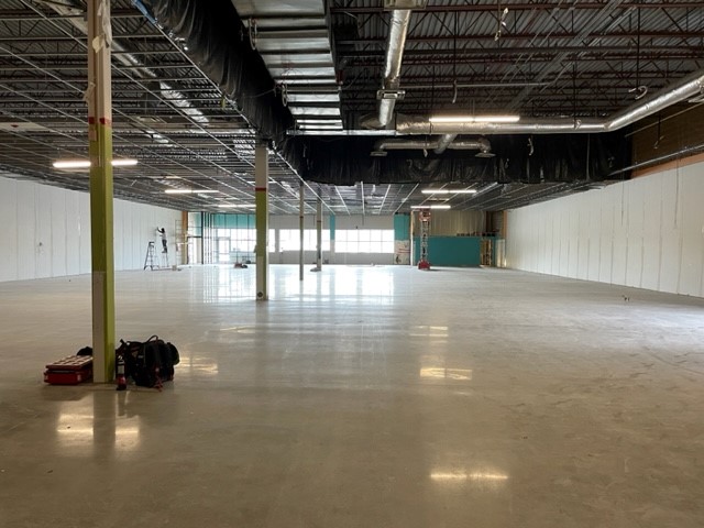 A large, empty room with no ceiling, and very shiny waxed floors.