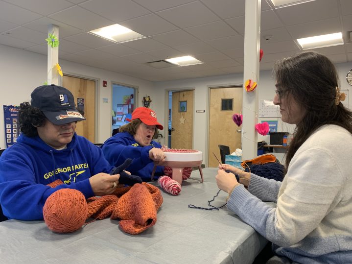 Woman knitting with clients at Goodwill LifeWorks Deaf Services