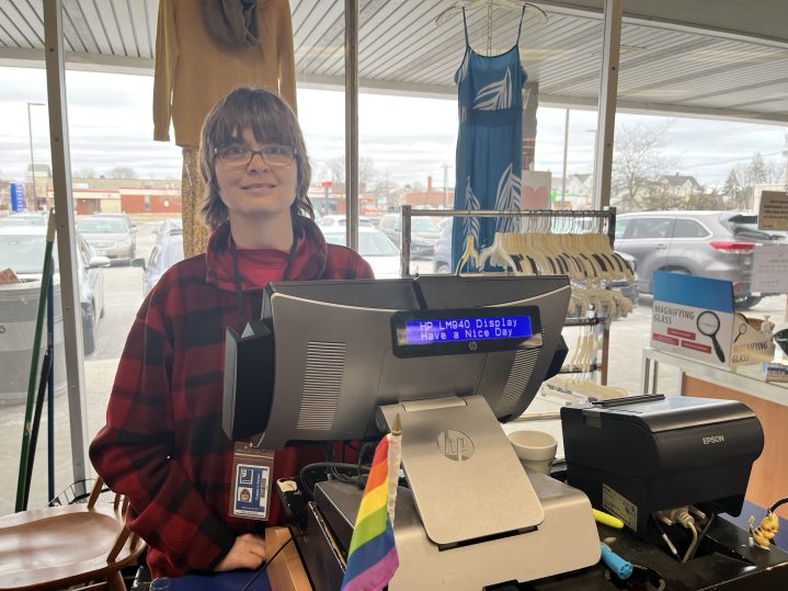 Goodwill employee, Tammy, stands smiling behind the register of the Goodwill Mill Creek South Portland store.