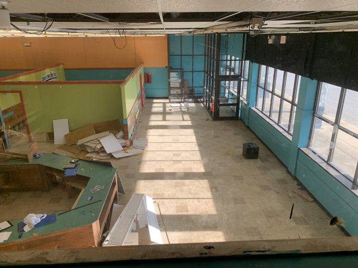 The bird's eye view of a large, empty room with no ceiling, and exposed hardware.