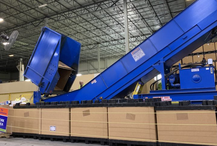 Giant bailer in the Goodwill NNE warehouse bails cardboard, plastic, and metal items. 