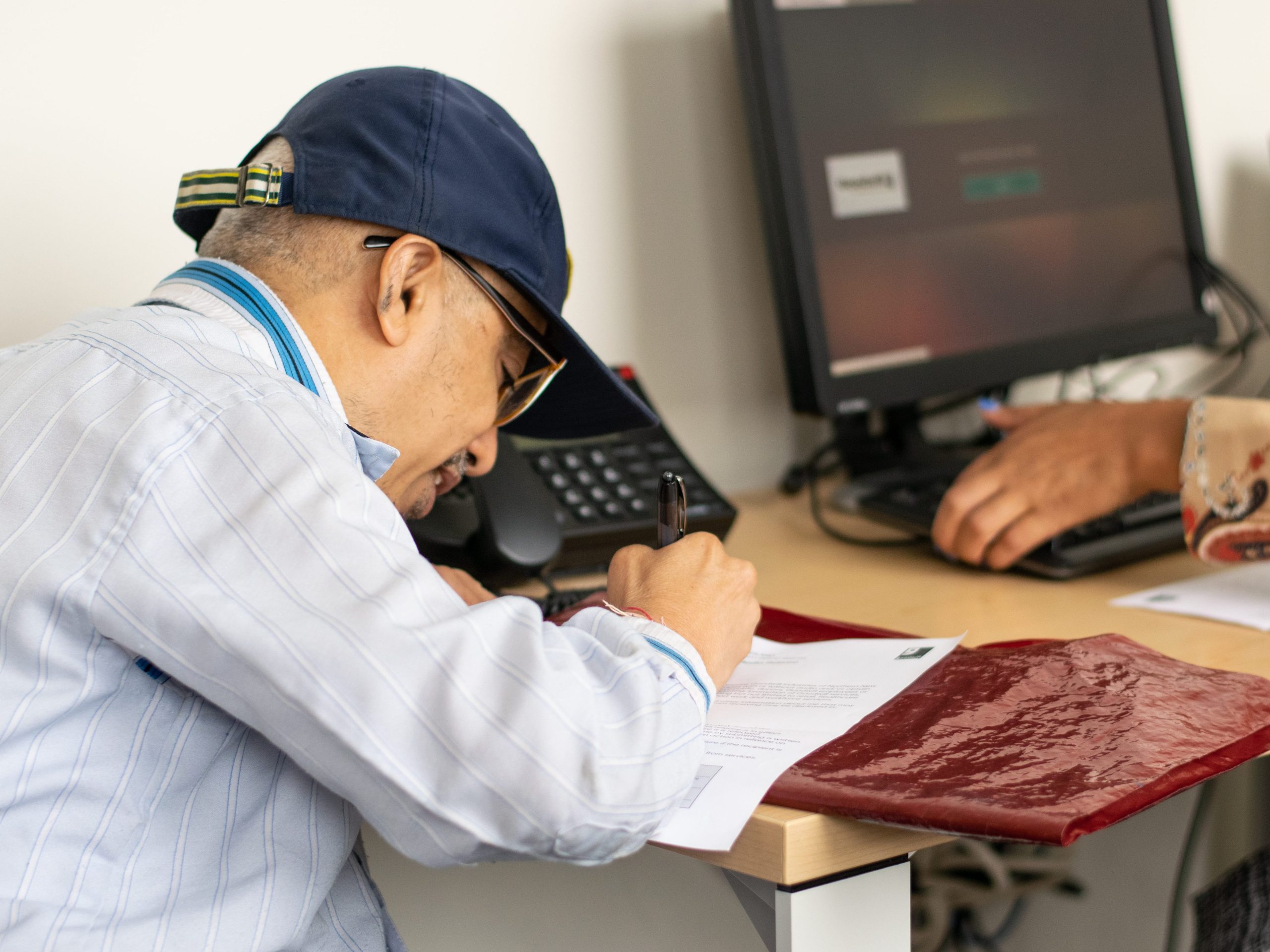 A workforce services client fills out an application with their career advisor.