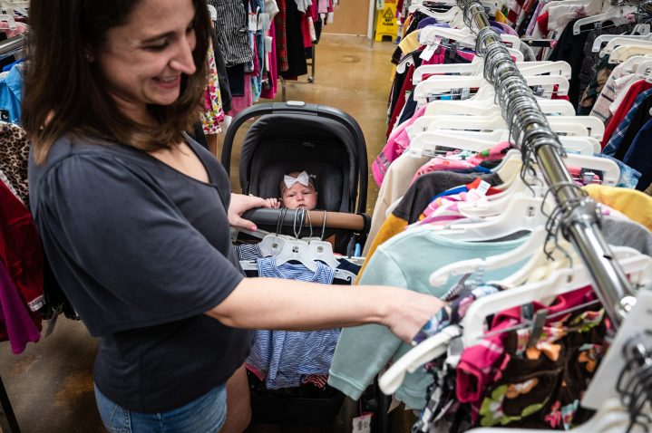 A woman shopping while pushing a stroller.