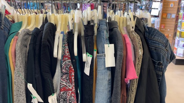 Clothing on a rack in a Goodwill store.