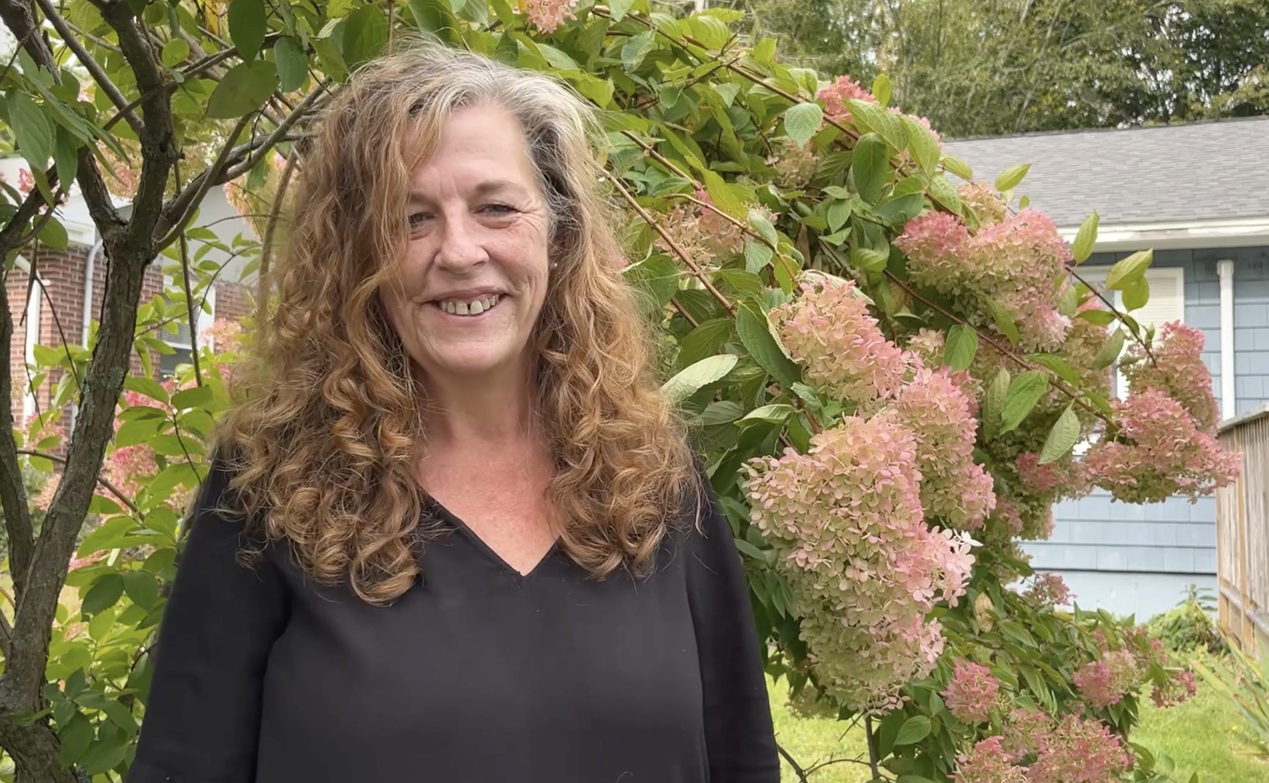 Debra Reynolds is smiling at the camera and wearing a black shirt.