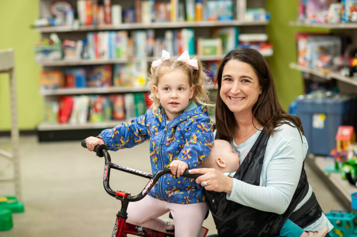 A woman with her two young children in a Goodwill store