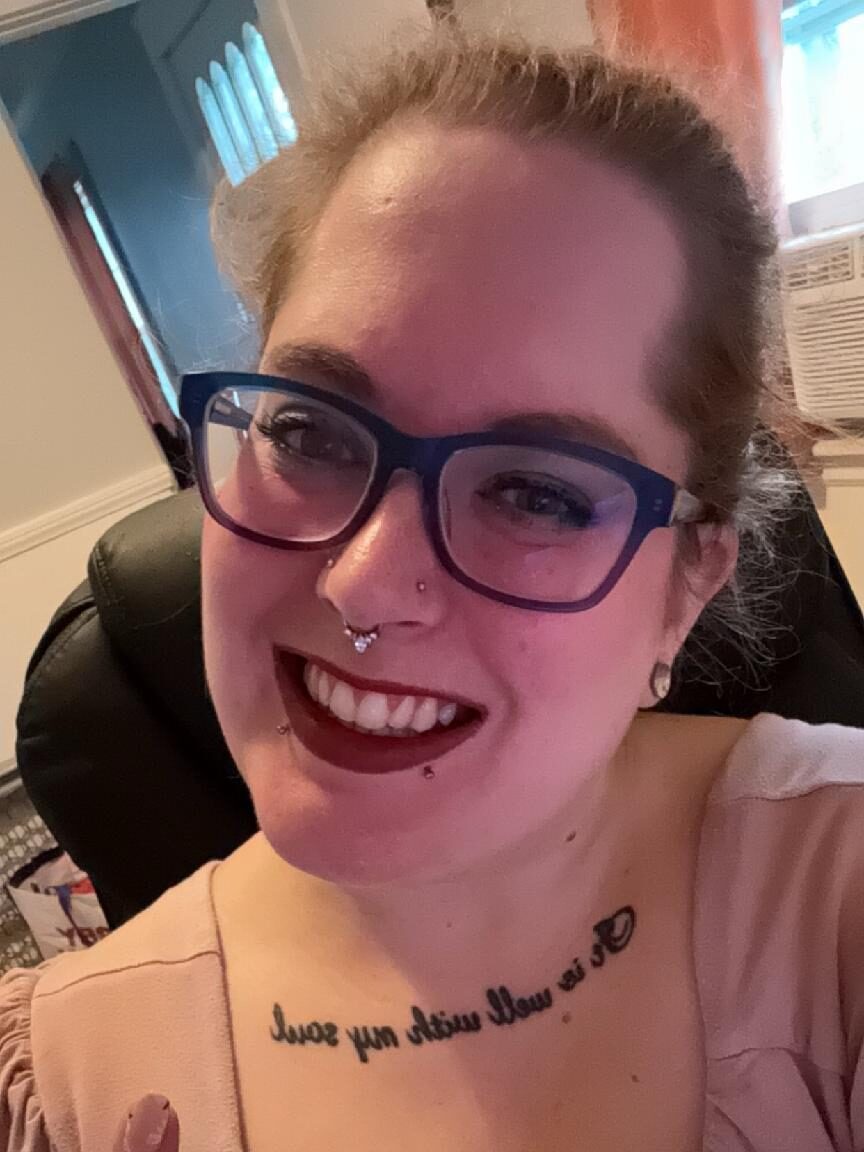 Keeley Moseley, a smiling woman wearing glasses and red lipstick. 