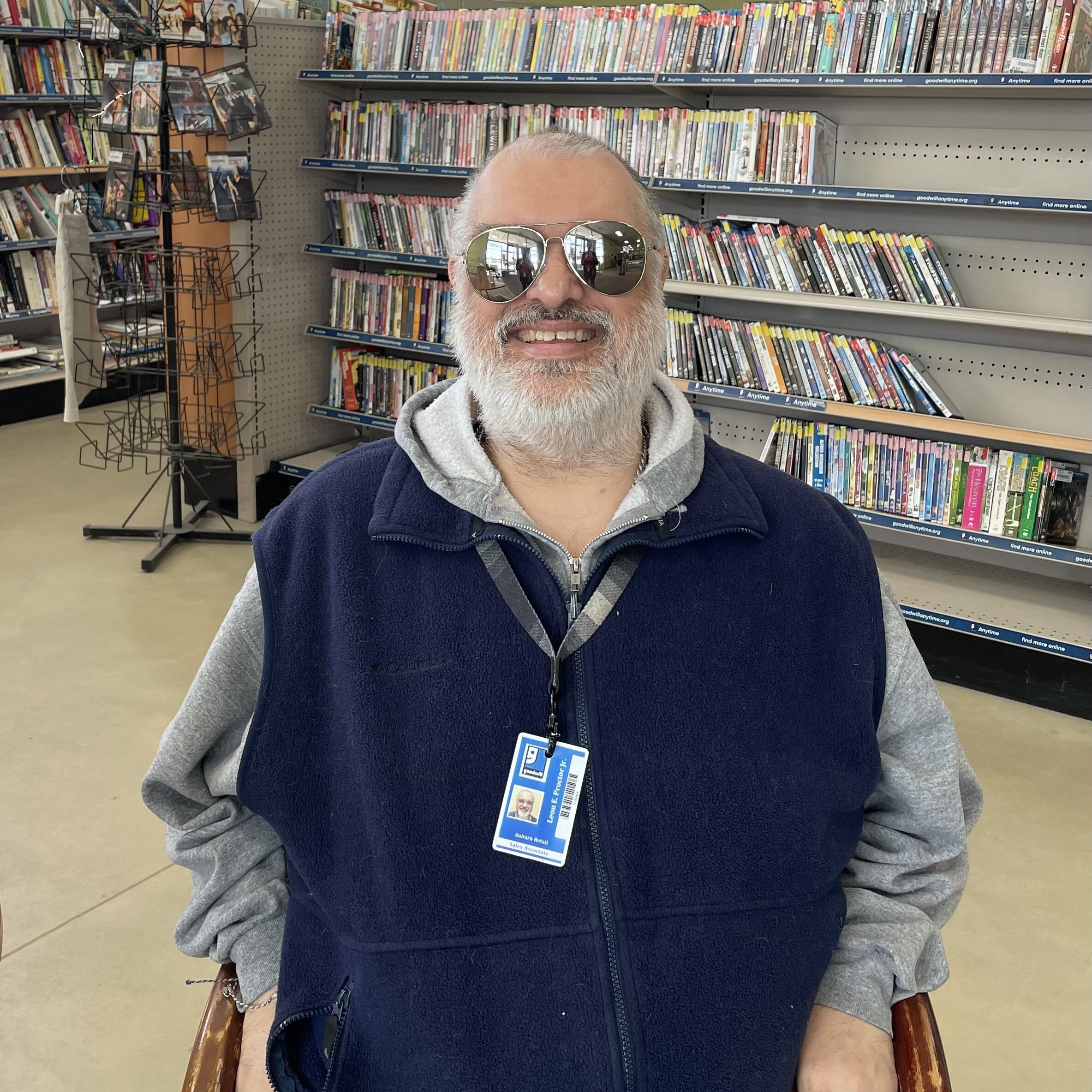 A man, Leon Proctor, sitting in a chair in a Goodwill store