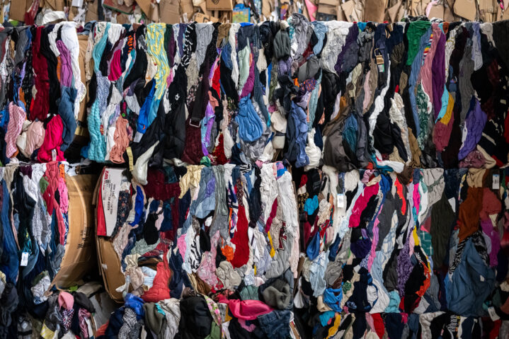 Many bales of textiles stacked on top of each other, demonstrating some of Goodwill Northern New England's sustainability practices.