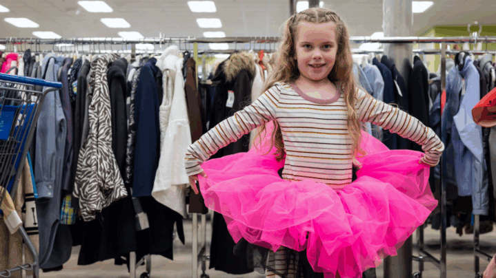 A young girl celebrates Halloween sustainably by posing with her Goodwill thrifted tutu