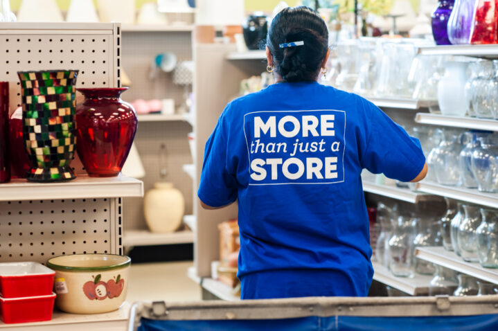 Goodwill employee stocking shelves of store